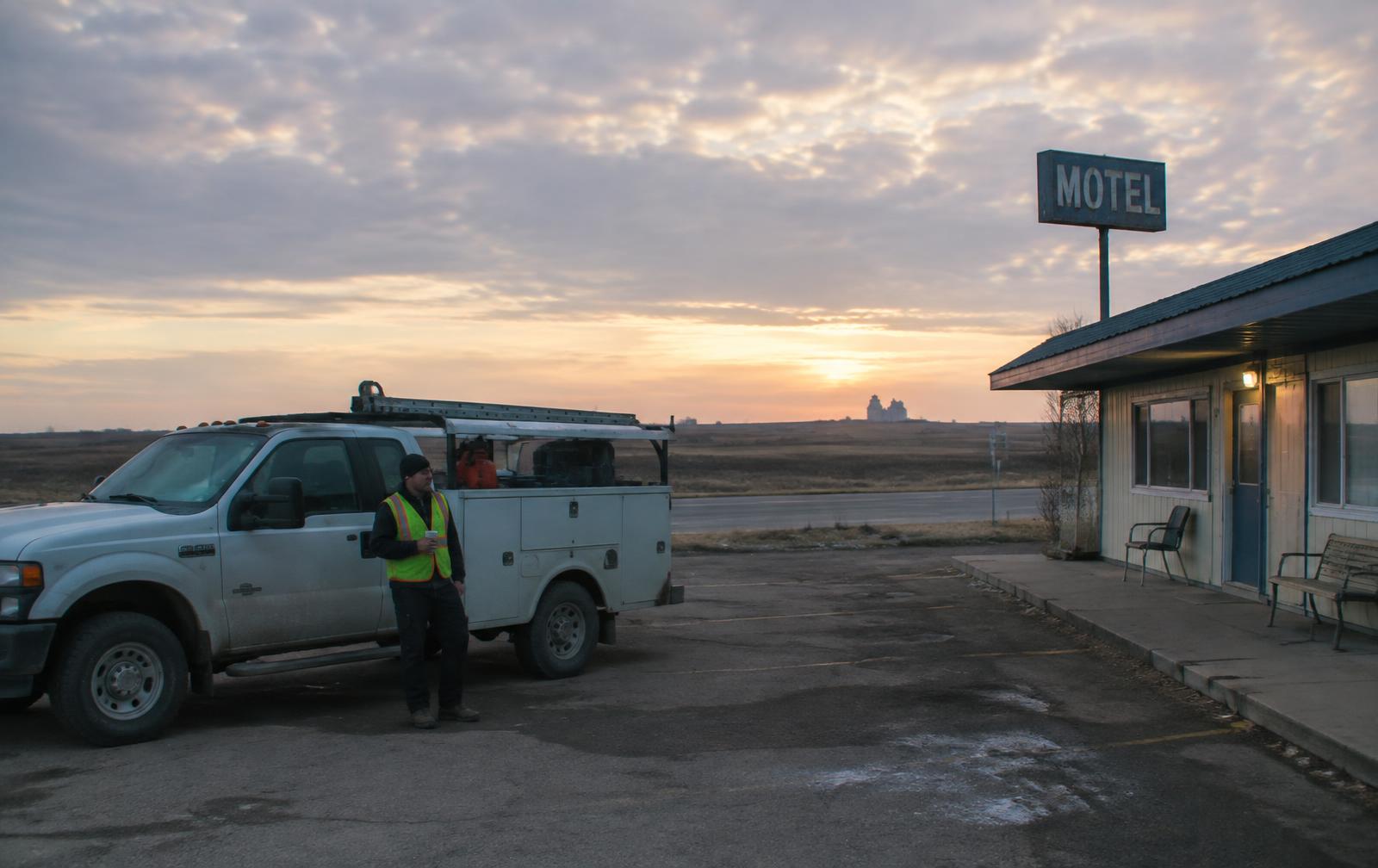 Work truck parked outside roadside lodging at sunrise
